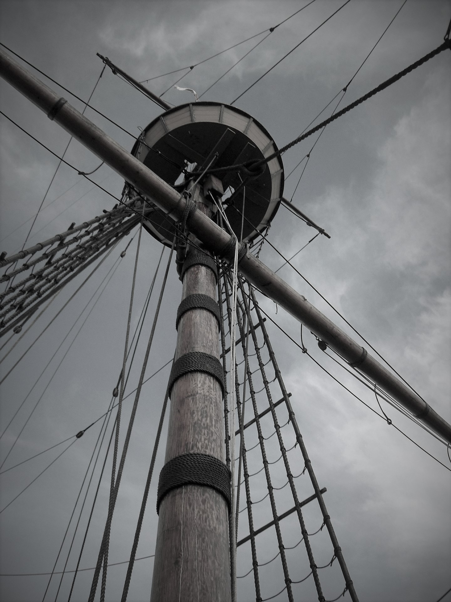 Black and white low angle shot of a ship mast.
