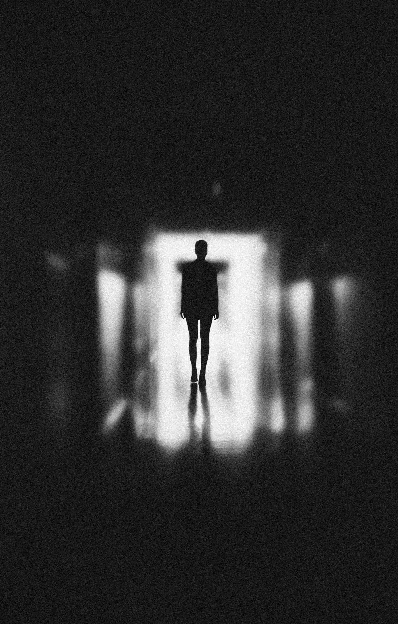 Monochrome photo of person standing in a hallway